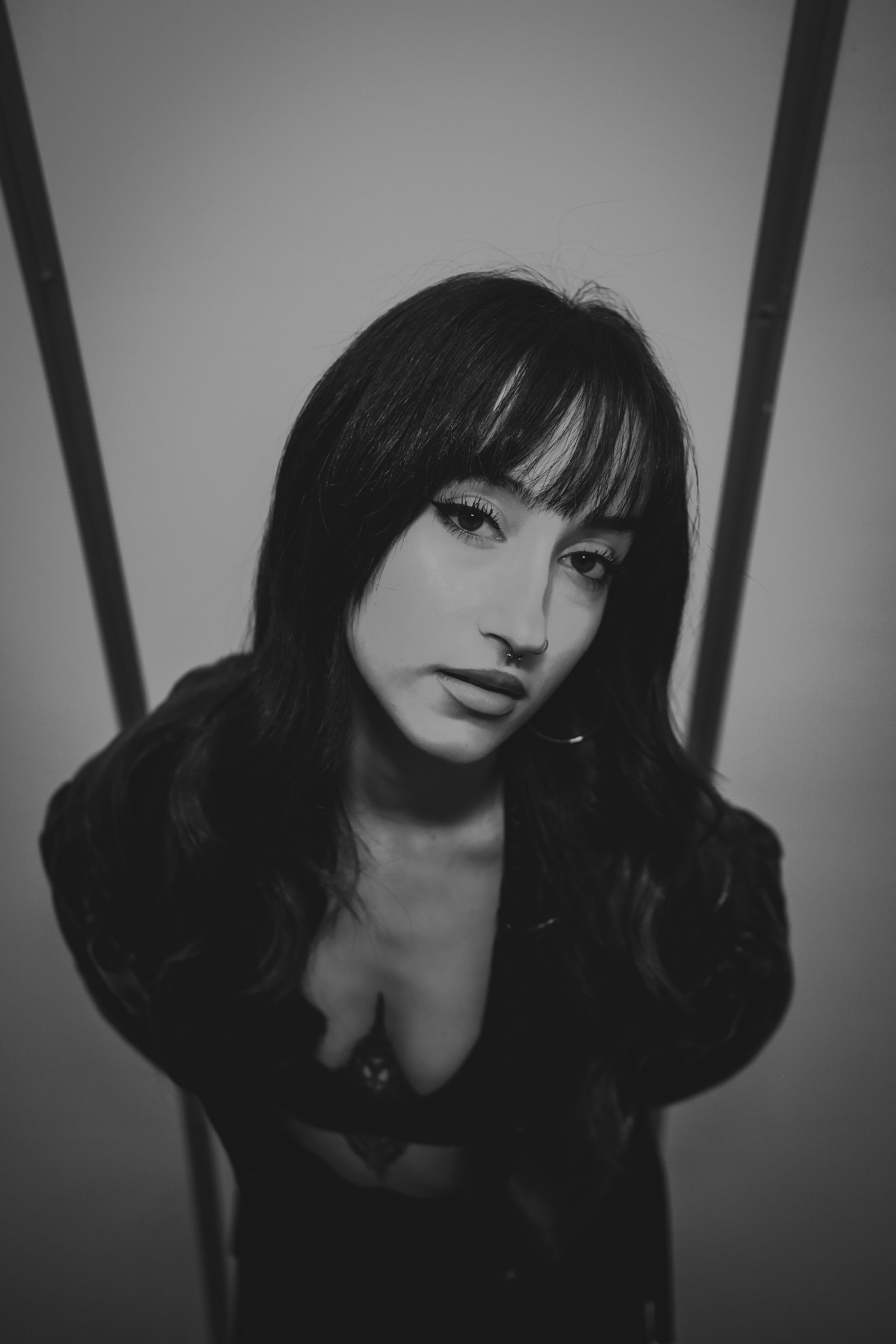 Black and white editorial portrait of a woman with dark hair and a fringe